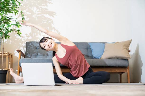 A woman doing yoga while looking at the computer screen in the room